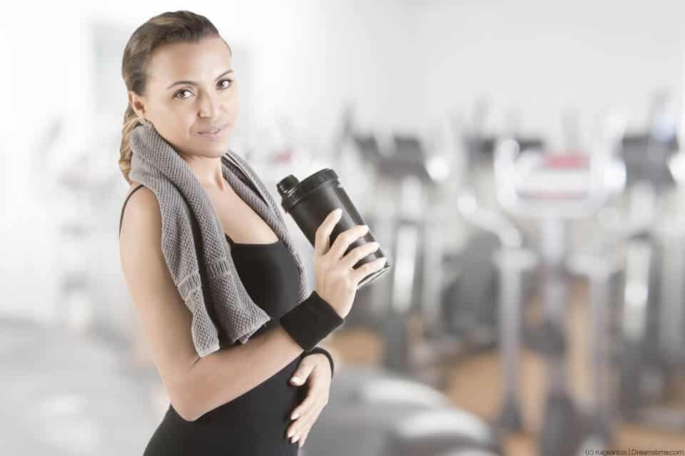 Lady in the gym about to drink a pre-workout supplement drink